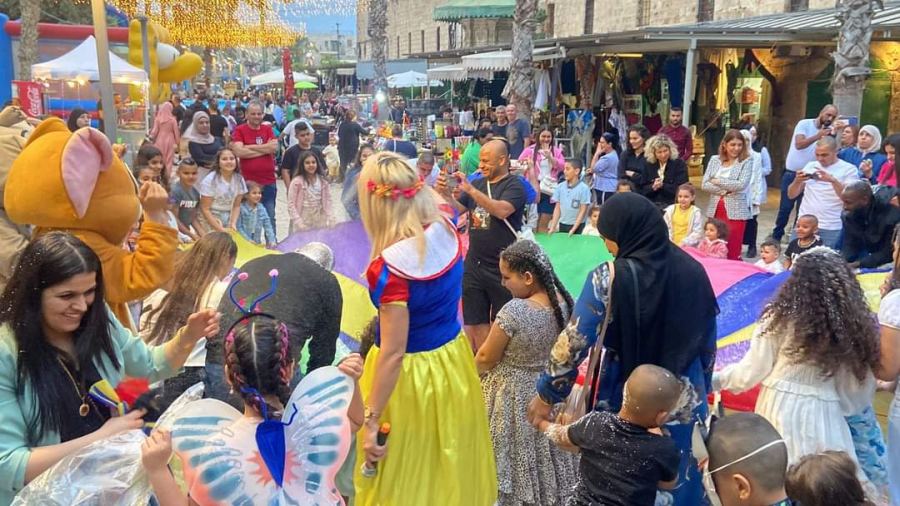 فنانون يرسمون البسة على وجوه اطفال عكا